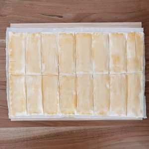 Blätterteig mit Eigelb eingepinselt und in 16 Stücke geschnitten