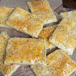 Blätterteigtaschen mit Schinken und Käse auf einem Backpapier