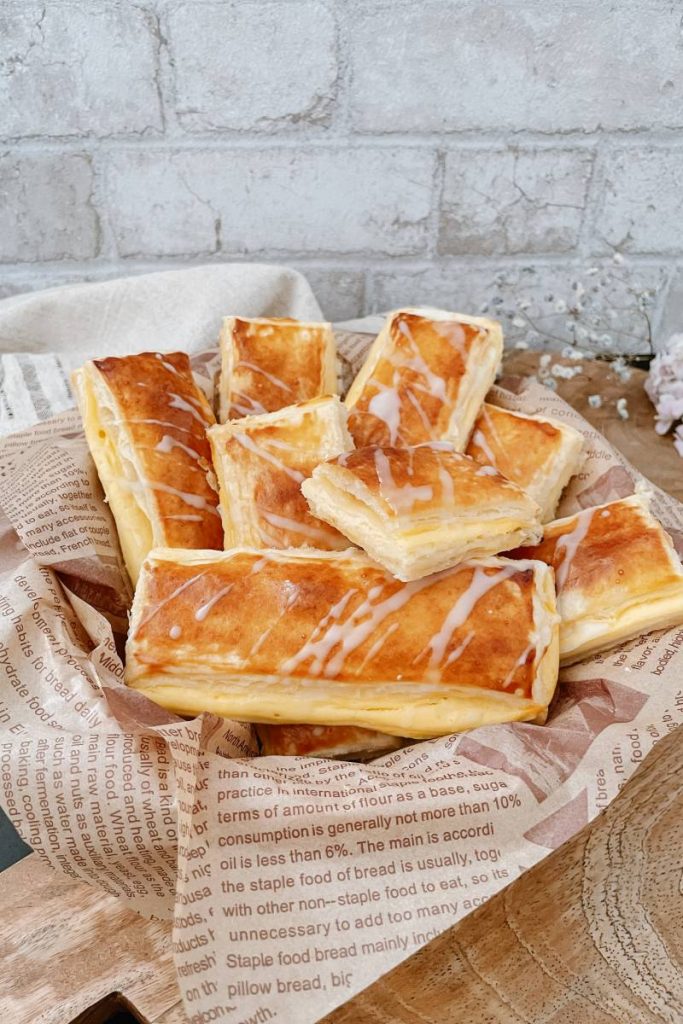 Goldbraune Vanillepuddingstangen mit Zuckerguss in einem Brotkorb