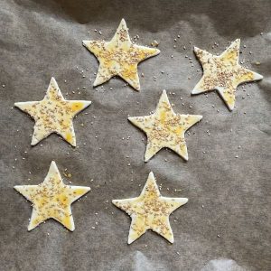Blätterteigsterne mit Eigelb eingepinselt und mit Sesam bestreut