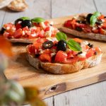 Bruschetta Caprese mit frischem Basilikum serviert