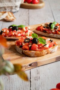Bruschetta Caprese mit frischem Basilikum serviert