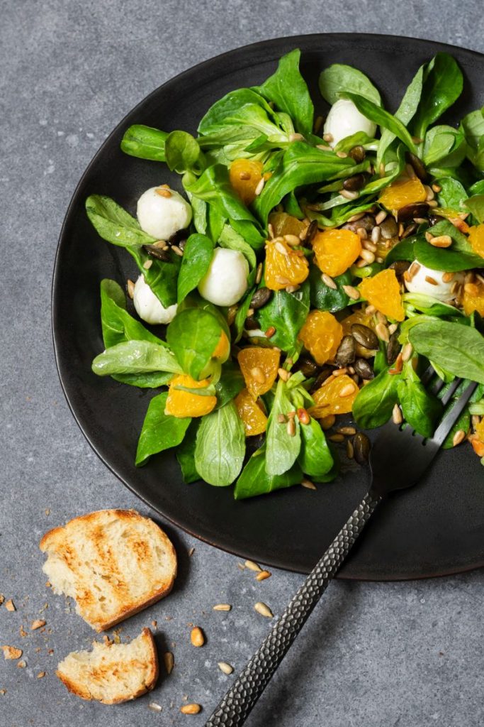 Feldsalat mit Orangen und Mozzarella serviert mit Brot
