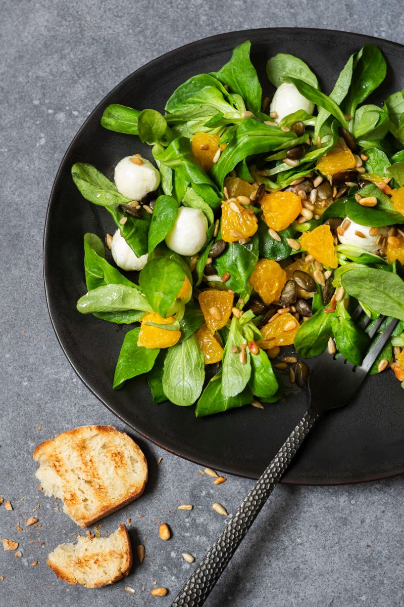 Feldsalat mit Orangen und Mozzarella serviert mit Brot