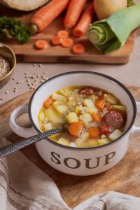 Graupensuppe mit Mettenden serviert in einer Suppenschüssel