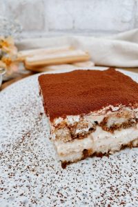 Ein Stück Tiramisu auf einem Teller serviert