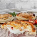 Aufgeschnittener Rustico auf Backpapier mit herauslaufender Füllung