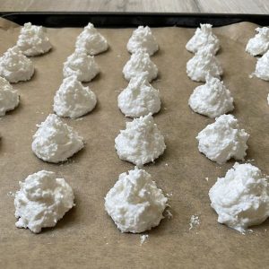 Geformte Kokosmakronen auf einem Backblech mit Backpapier
