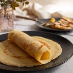 Pfannkuchen zusammengerollt auf einem Teller