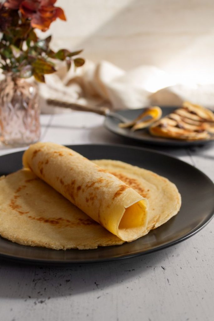 Pfannkuchen zusammengerollt auf einem Teller