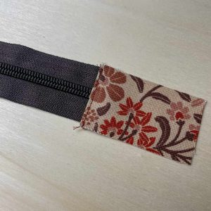 Stoffteil am Reißverschluss-Ende abgesteppt