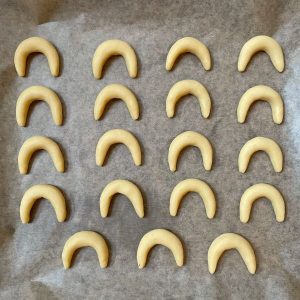 Vanillekipferl ungebacken auf einem Backblech mit Backpapier